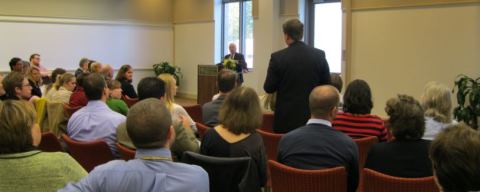 Higher Education doctoral student Sean Heuvel posing a question to Chancellor Gates at the School of Education