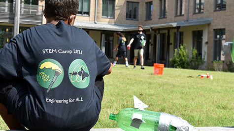 A camper watches as his peers test their rocket designs.