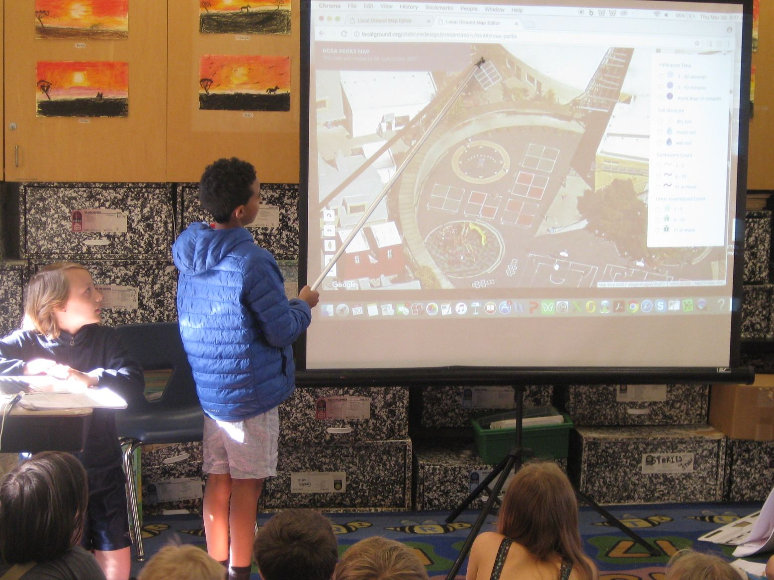 Two 11-year-old children sharing participatory GIS maps (Local Ground) of their schoolyard soil ecosystem. Photo Credit: Kathryn Lanouette.