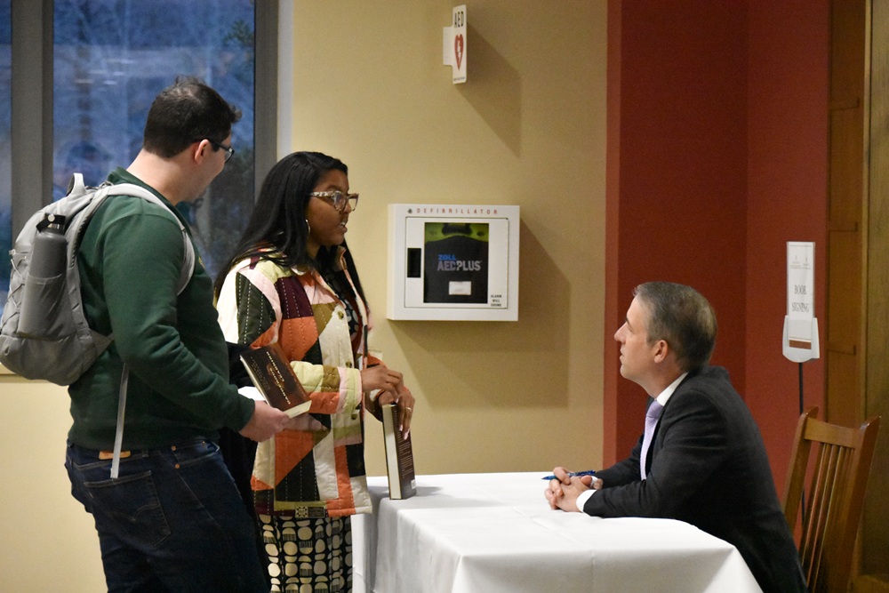 The author, School Psychology student Kelli Claiborne M.Ed. '25, Ed.S. '27. speaks with Professor Derek Black during his book signing.