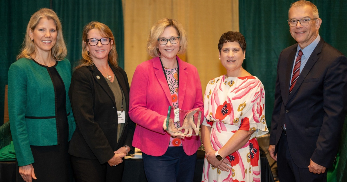 Associate Dean for Academic Affairs Lindy L. Johnson (center) and Clinical Assistant Professor April Lawrence (second from left) accepted the award on behalf of the School of Education.