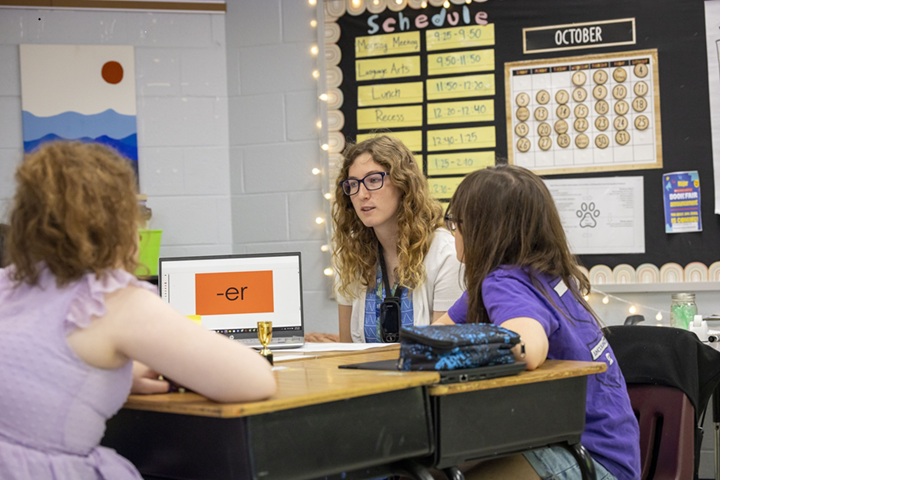 A William & Mary preservice teacher leads small group reading instruction with local elementary students.