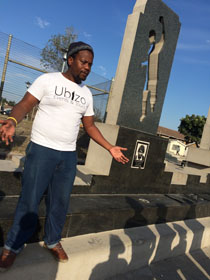 Langa resident and award-winning poet, Melisize Moni, performs his poem, ''A Moment of Silence.'' It is a tribute to the ''Gugulethu Seven,'' a group of anti-apartheid young men (ages 16-23) who were shot and killed by South African authories in 1986. The group watched Moni perform his poem in the Gugulethu township while standing in front of a monument honoring the seven men. Photo courtesy of Eddie R. Cole